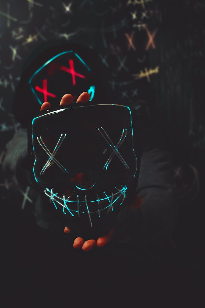Services-03 A mysterious neon mask with X eyes and a stitched smile, symbolizing rebellion and anonymity.